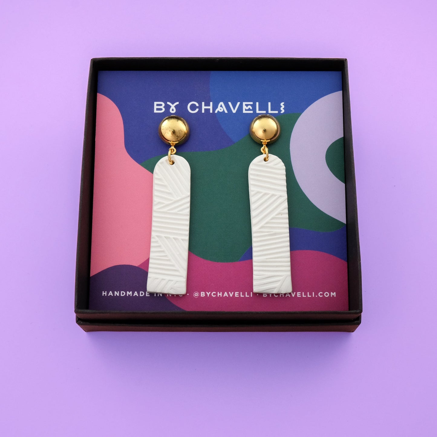 Elegant elongated Chelsea dangly earrings in textured white #color_white-textured-lines