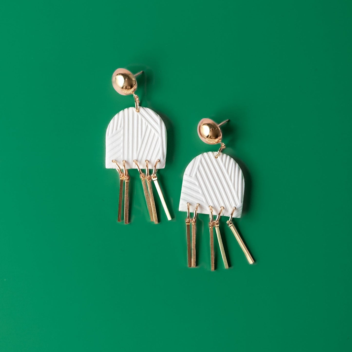Dancing Domes dangly earrings in white and gold #color_white-textured-lines