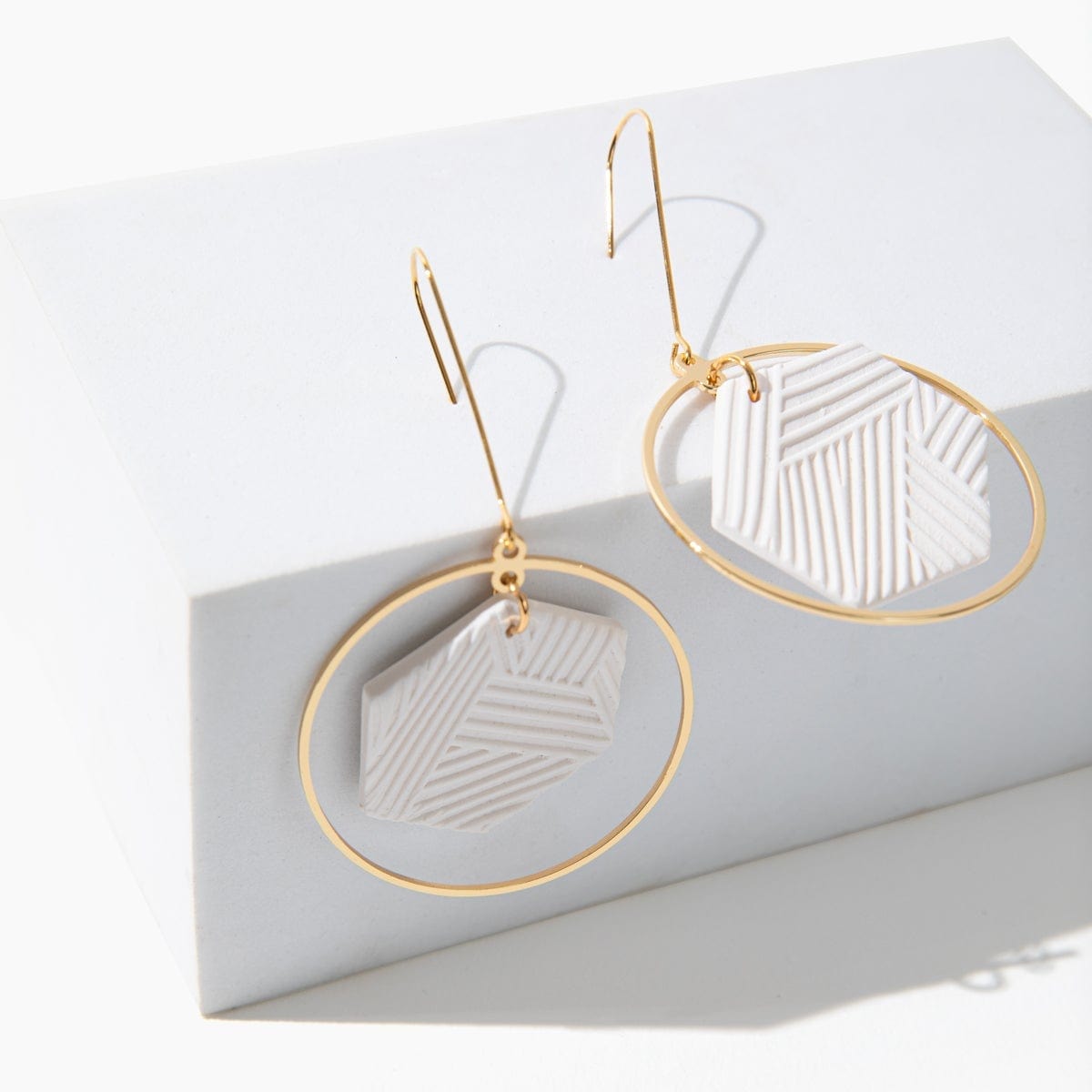 Hex Halo Dangly hexagon shaped elegant and lightweight white and gold earrings #color_white-textured-lines