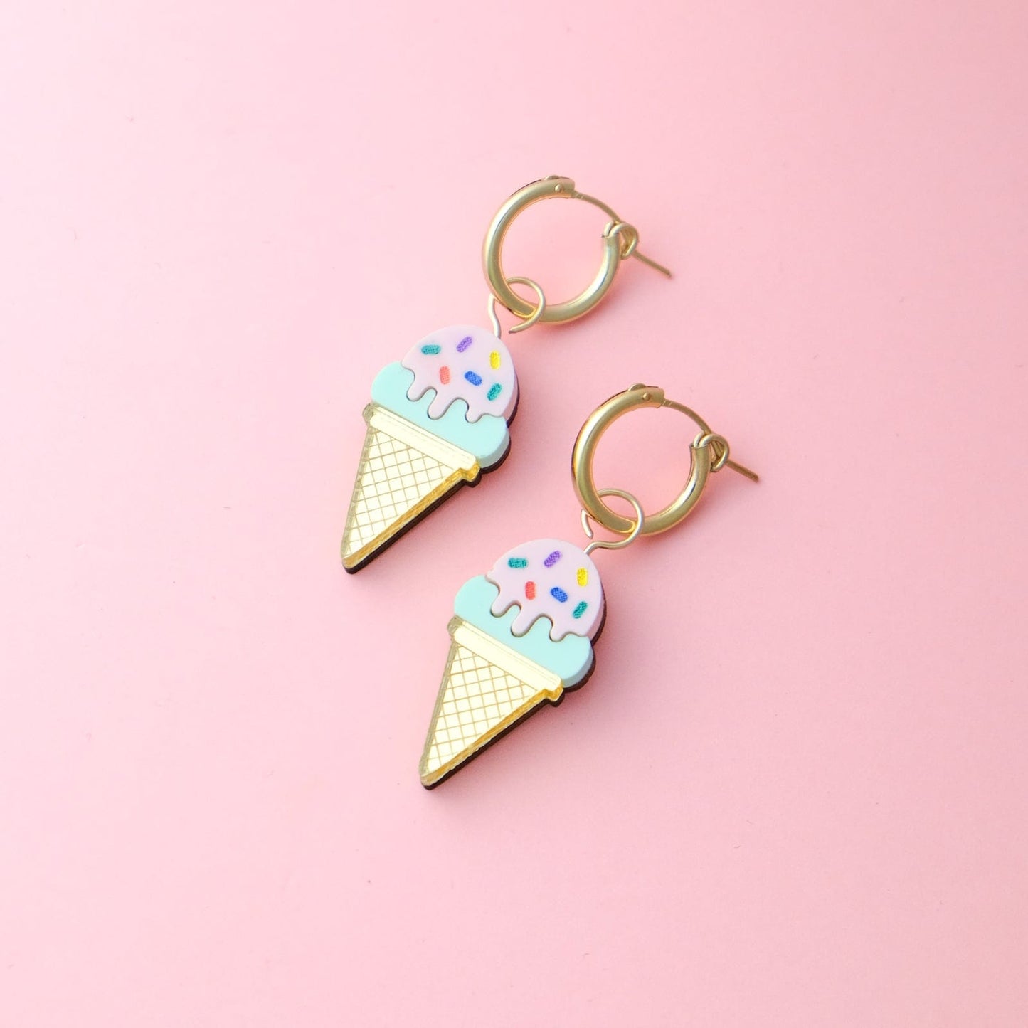 Colorful sprinkles ice cream cone hoop earrings By Chavelli, featuring a dainty gold hoop with a playful acrylic ice cream cone charm decorated with rainbow sprinkles #color_sprinkles