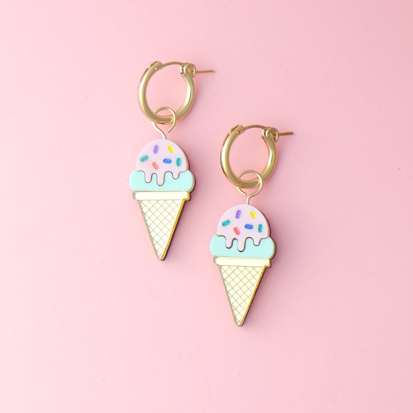 Colorful sprinkles ice cream cone hoop earrings By Chavelli, featuring a dainty gold hoop with a playful acrylic ice cream cone charm decorated with rainbow sprinkles #color_sprinkles