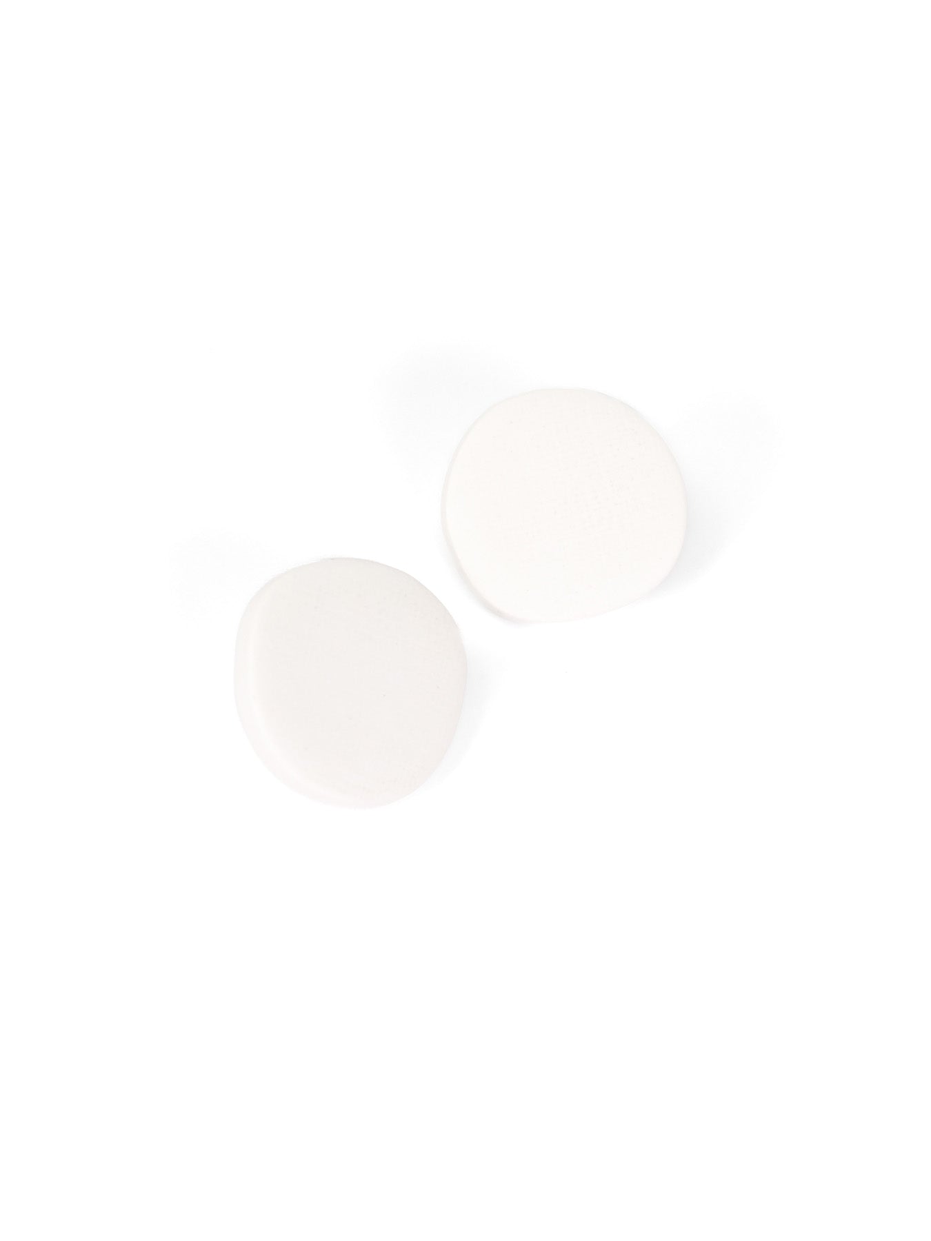 Minimal pebble-shaped stud earrings in crisp matte white with a soft-touch finish #color_white