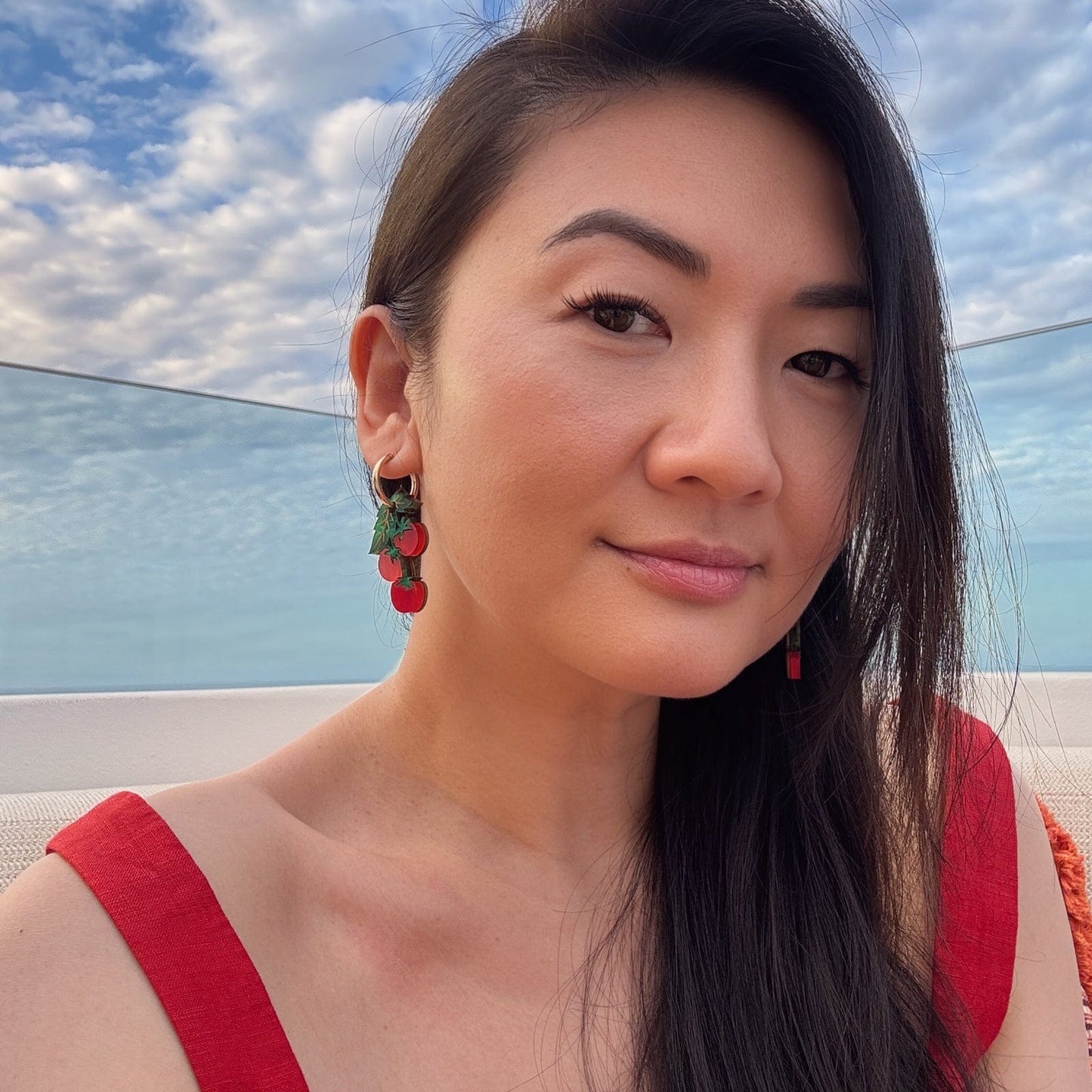 Tomato-vine dangle earrings, polished gold huggie hoops, layered acrylic charms, etched leafy details, clustered cherry shapes in vivid tomato red #color_red