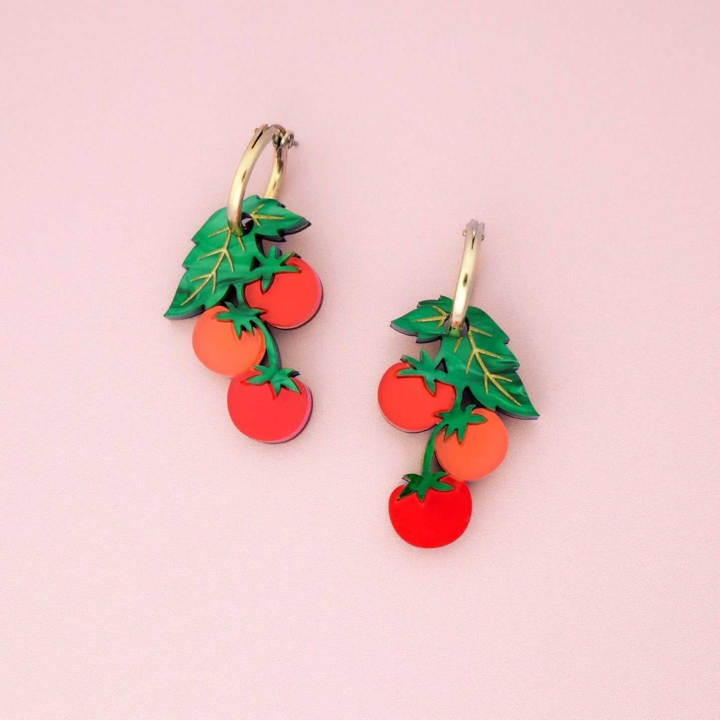 Tomato-vine dangle earrings, polished gold huggie hoops, layered acrylic charms, etched leafy details, clustered cherry shapes in vivid tomato red #color_red