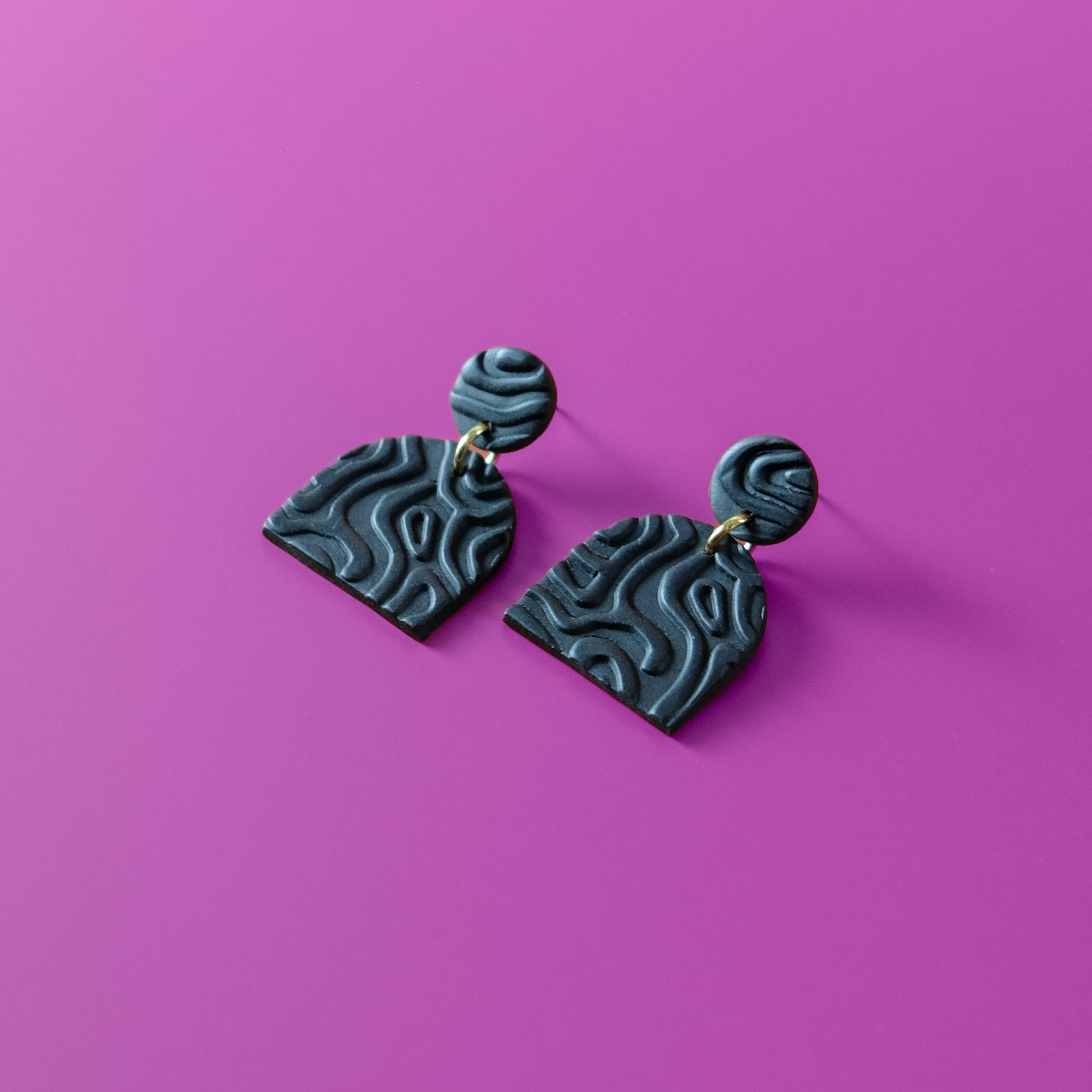 Alexa Domes lightweight dangly earrings in textured black #color_black-topographic-texture