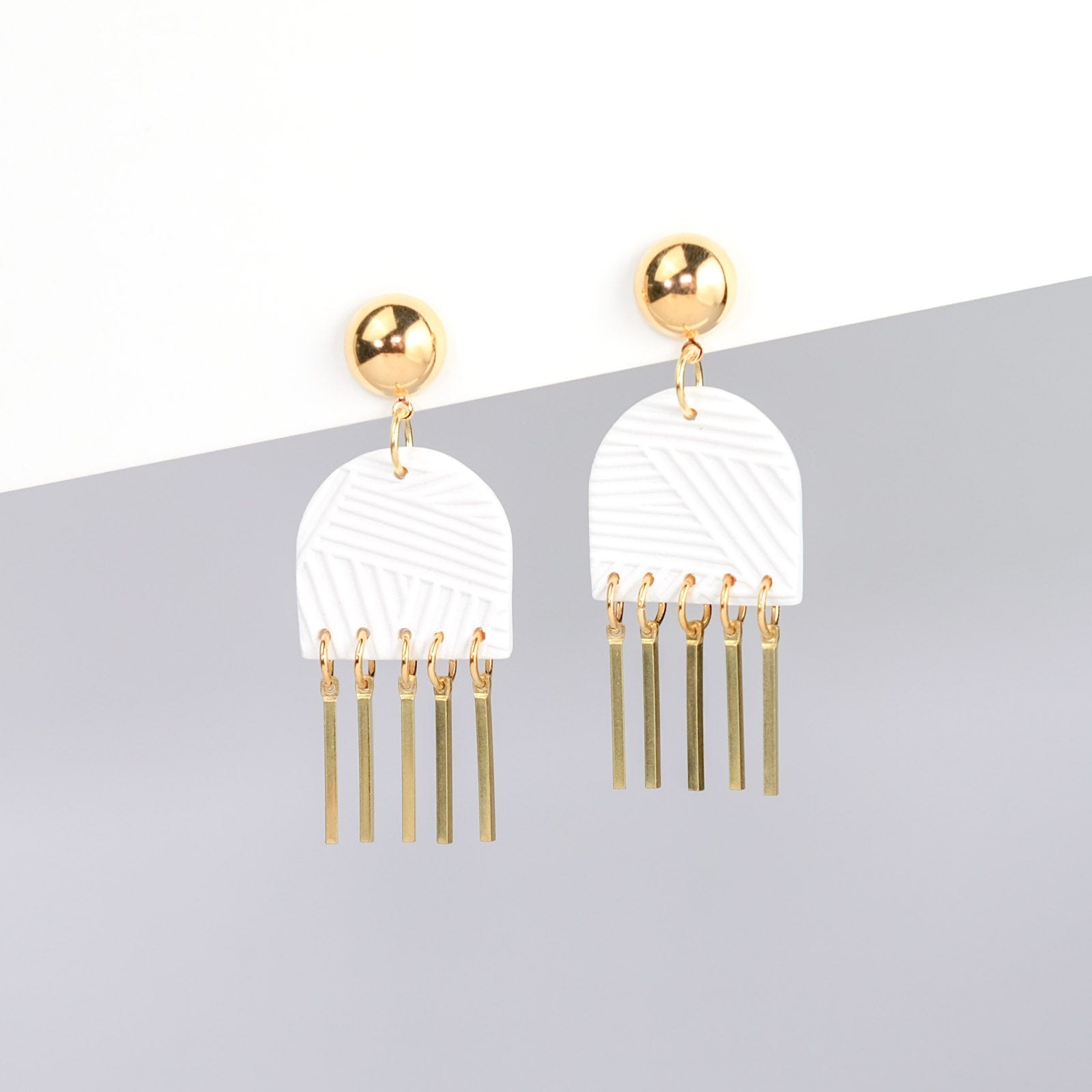 Dancing Domes dangly earrings in white and gold #color_white-textured-lines