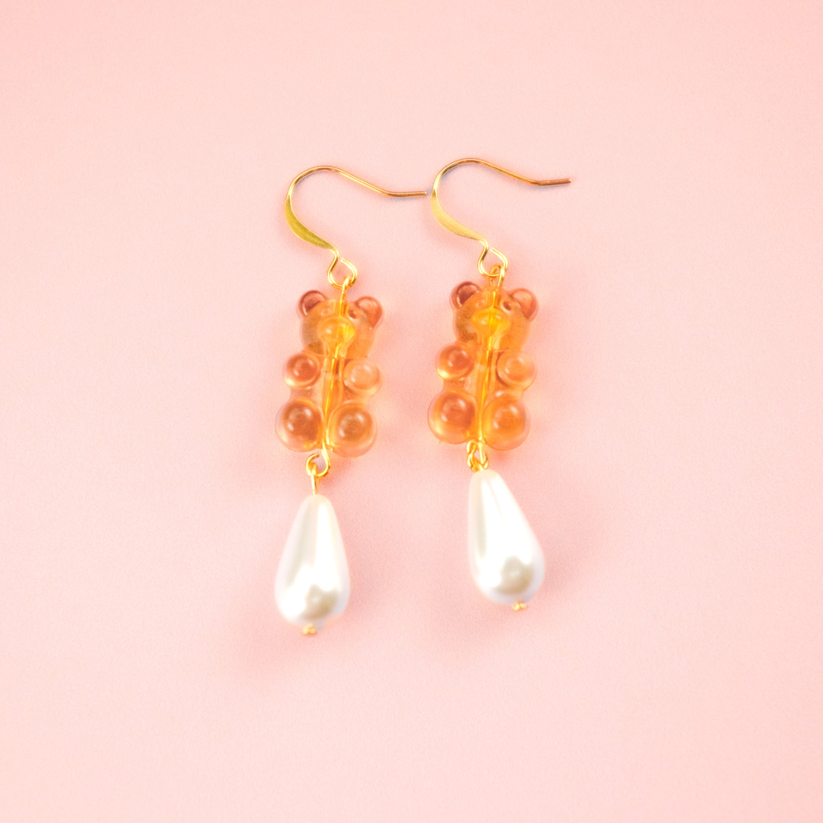Nostalgic orange gummy bear dangly earrings with elegant pearl drops #color_orange