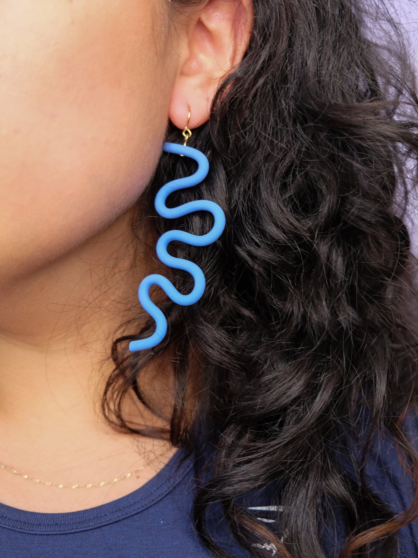 lavender wavy earring, artistic, sculpted, drop-length, smooth, worn by a person with dark hair #color_lavender