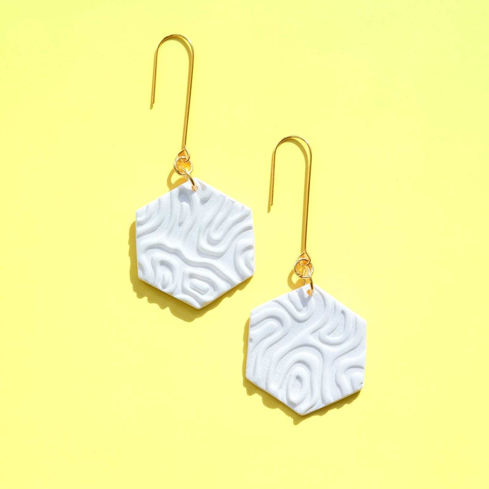 Swinging Hex Dangly Earrings #color_white-topographic-texture