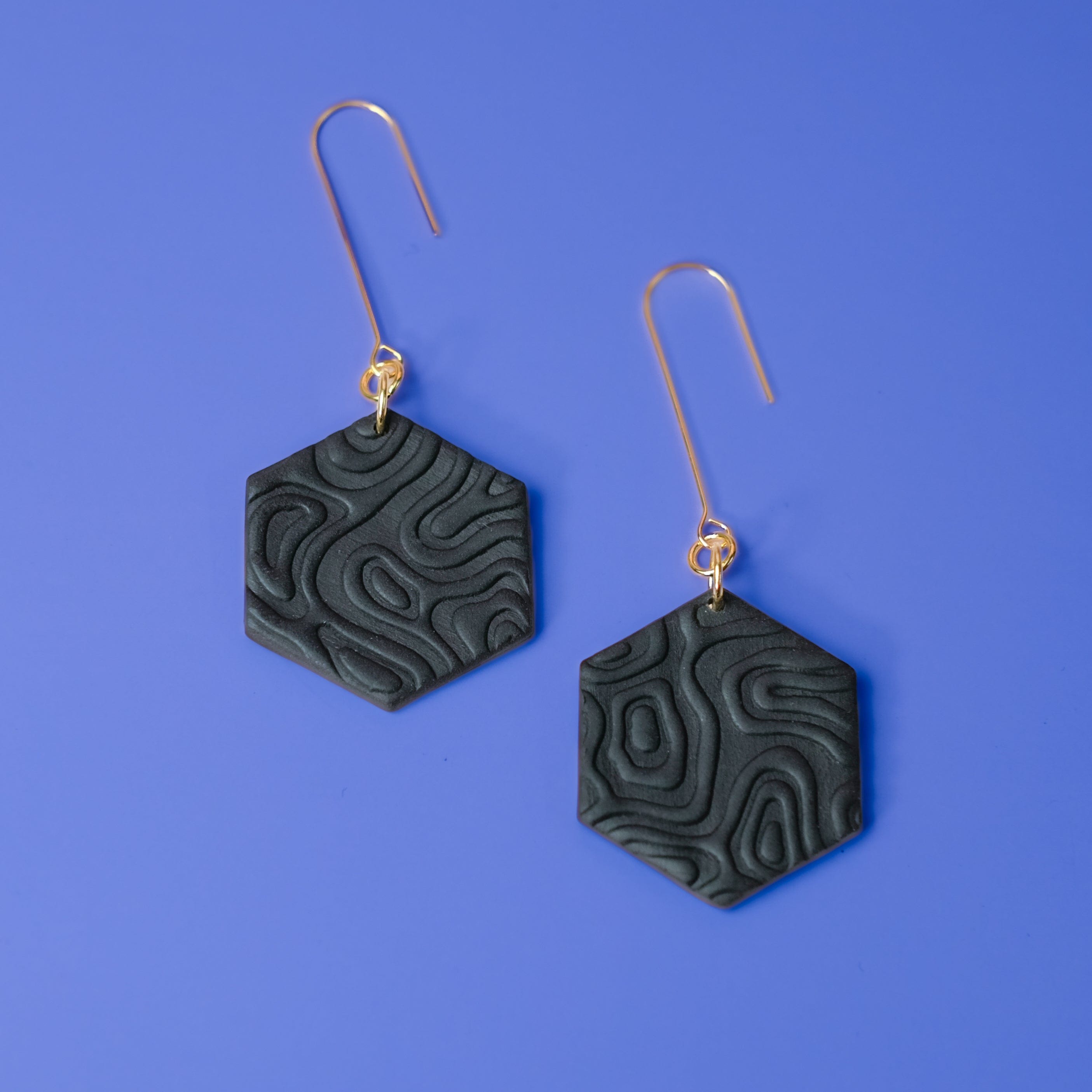 Swinging Hex Dangly Earrings #color_black-topographic-texture