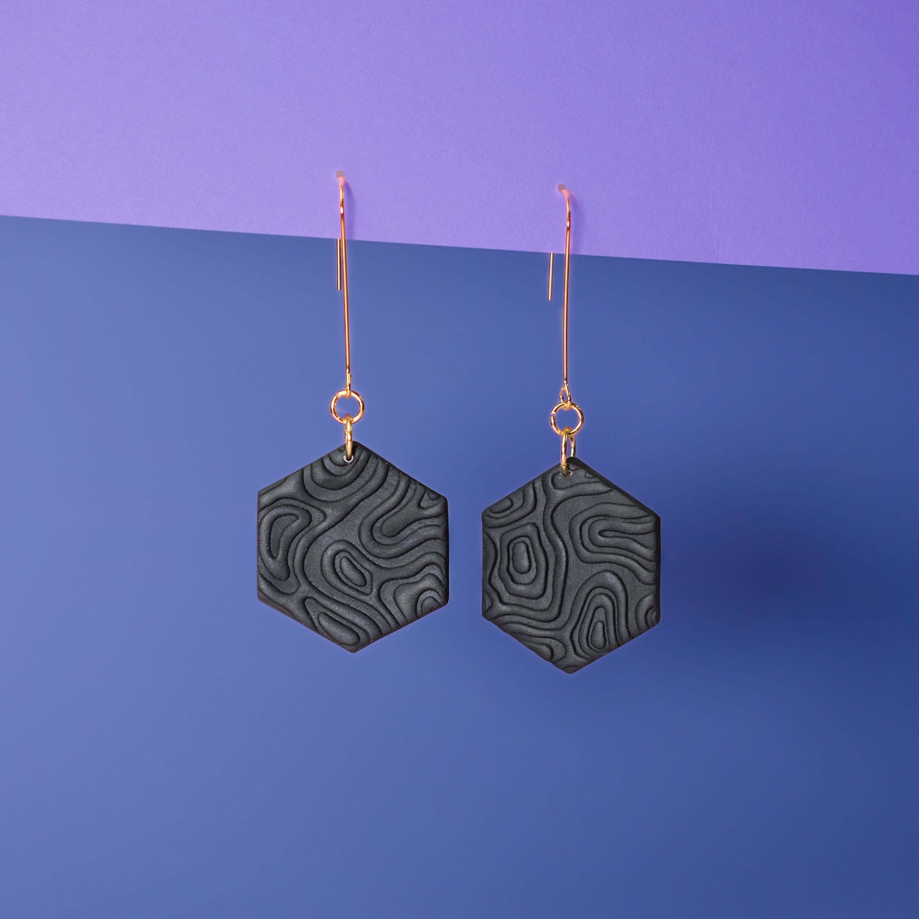 Swinging Hex Dangly Earrings #color_black-topographic-texture