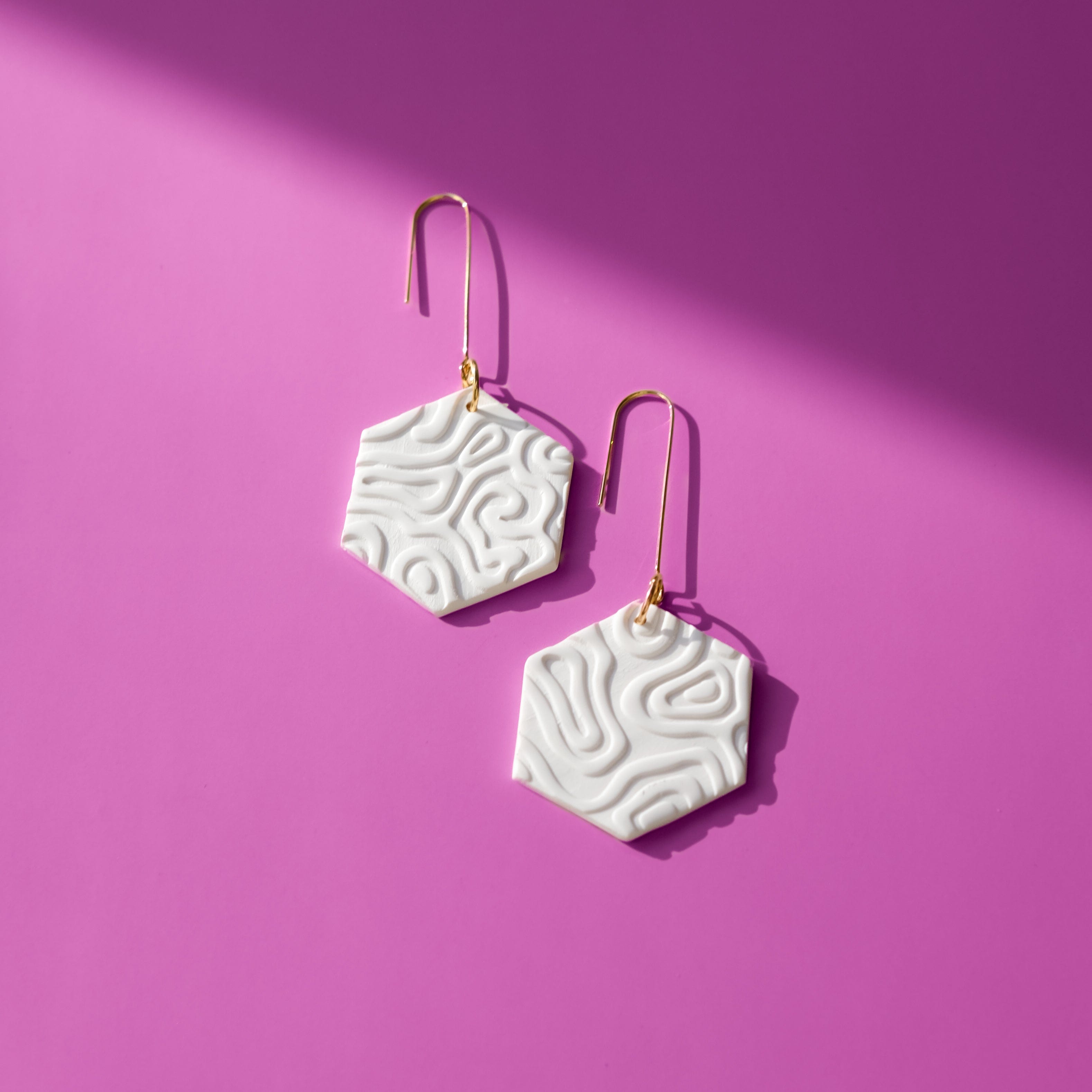 Swinging Hex Dangly Earrings #color_white-topographic-texture